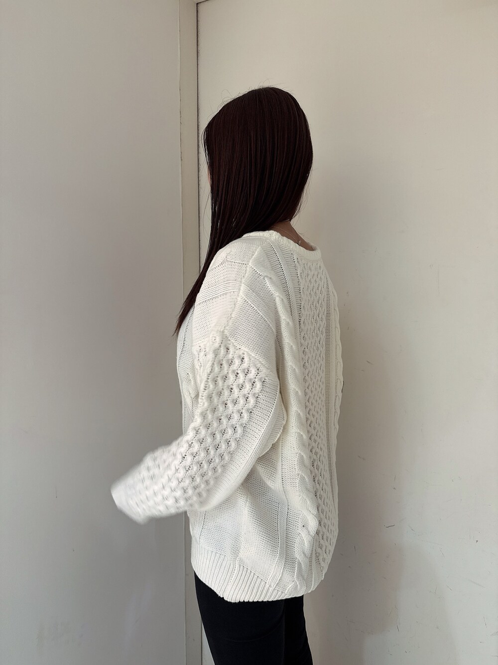 ホワイト系のニット/セーター、ブラック系のデニムパンツ、ブラック系のブーツを着用したレディースの秋コーディネートの5枚目の写真