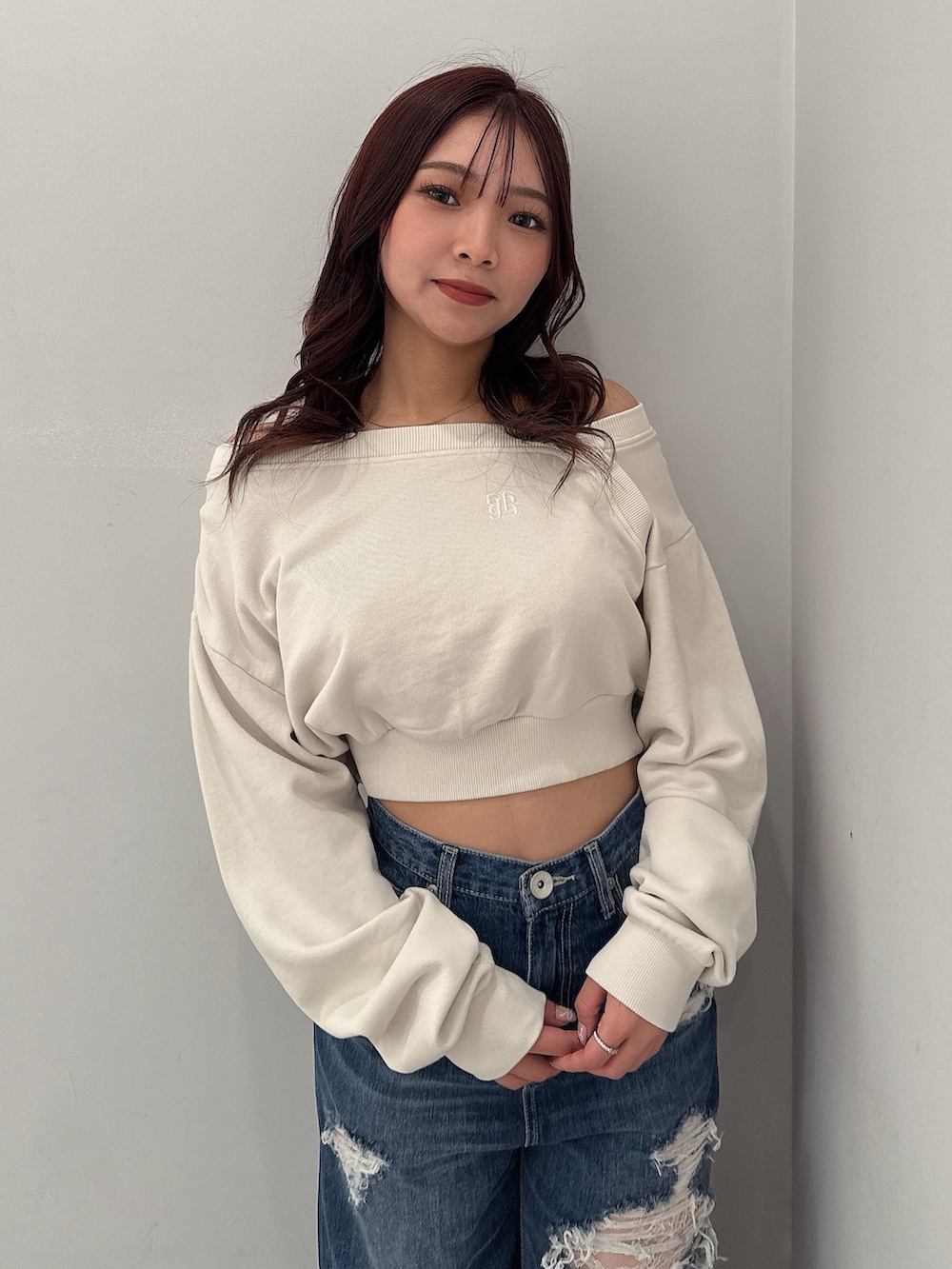 ホワイト系のスウェット、ブルー系のデニムパンツ、ブラック系のブーツを着用したレディースの秋コーディネートの4枚目の写真