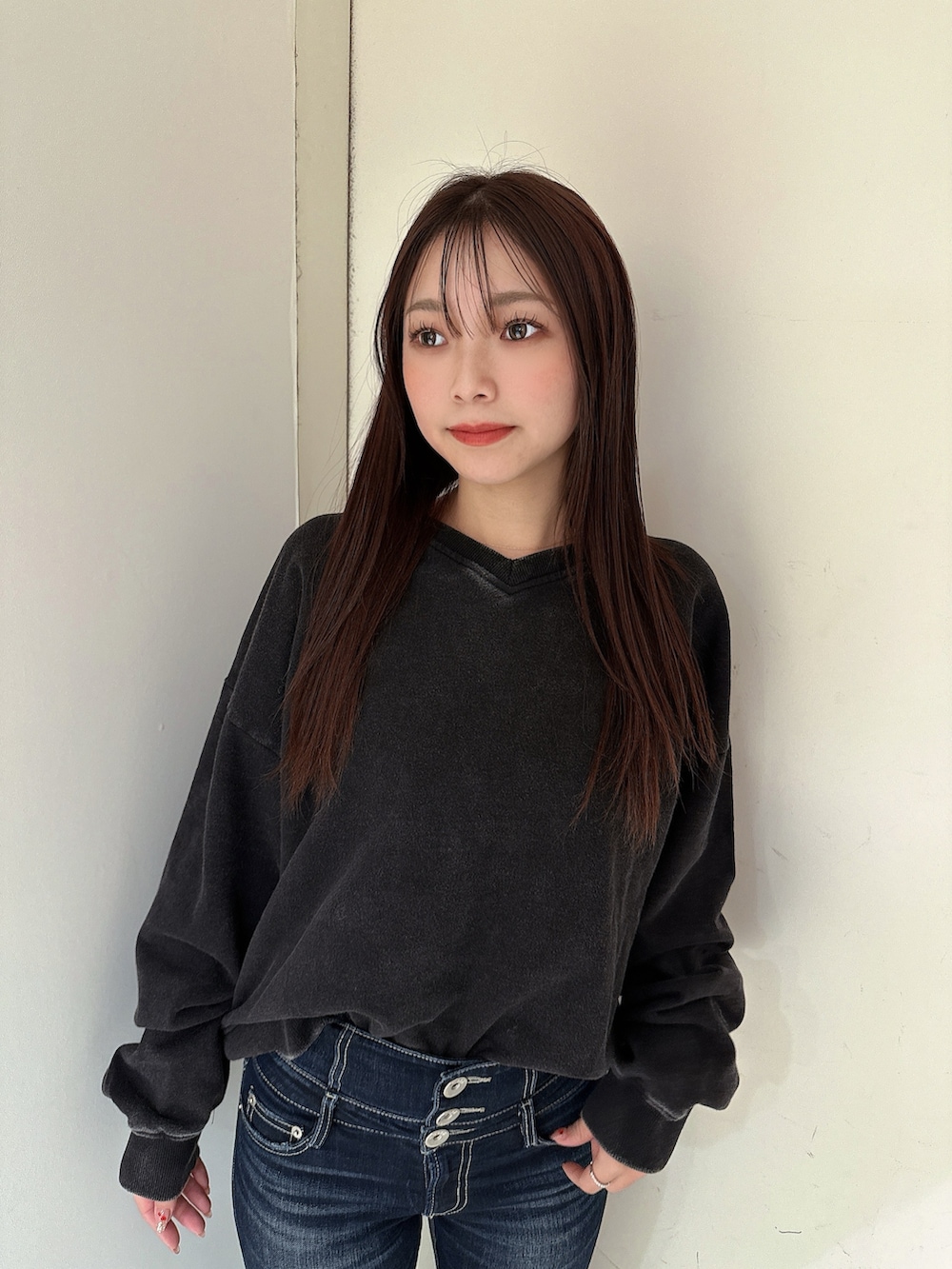 ブルー系のデニムパンツ、ブラック系のスウェット、ブラック系のブーツを着用したレディースの冬コーディネートの4枚目の写真