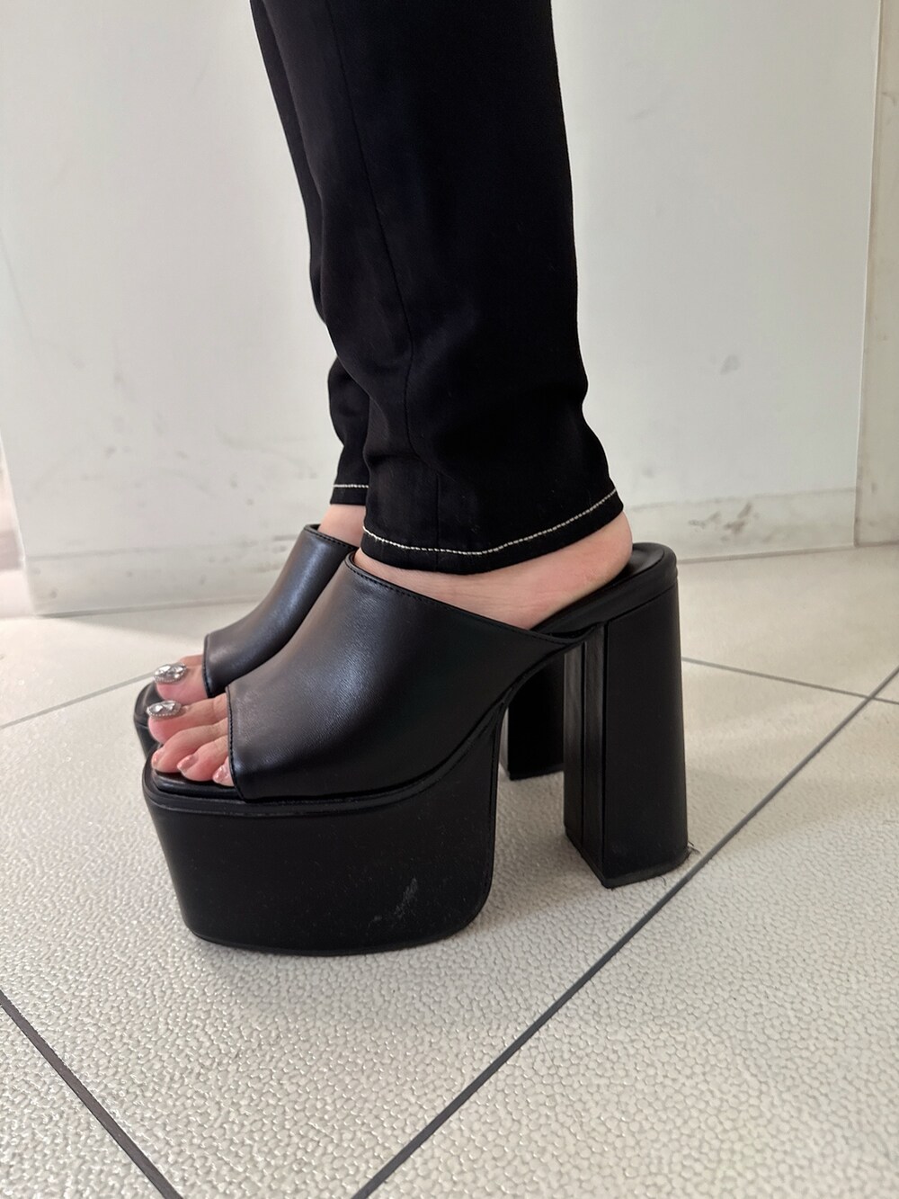 ブラック系のデニムパンツ、ブラック系のサンダル、ホワイト系のシャツ/ブラウスを着用したレディースの夏コーディネートの8枚目の写真