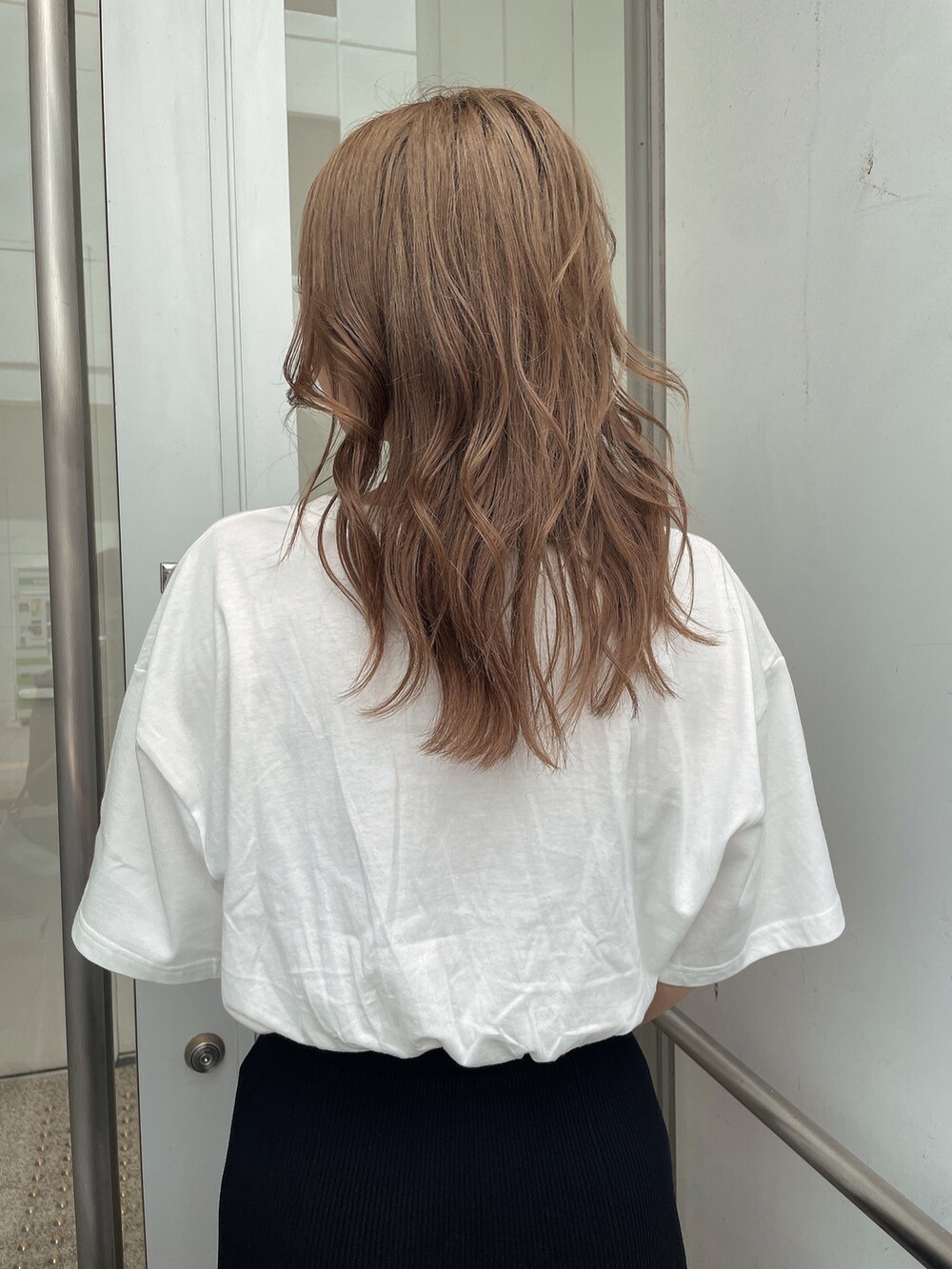 ブラック系のスカート、ブラック系のハンドバッグ、ホワイト系のTシャツ/カットソーを着用したレディースの夏コーディネートの6枚目の写真