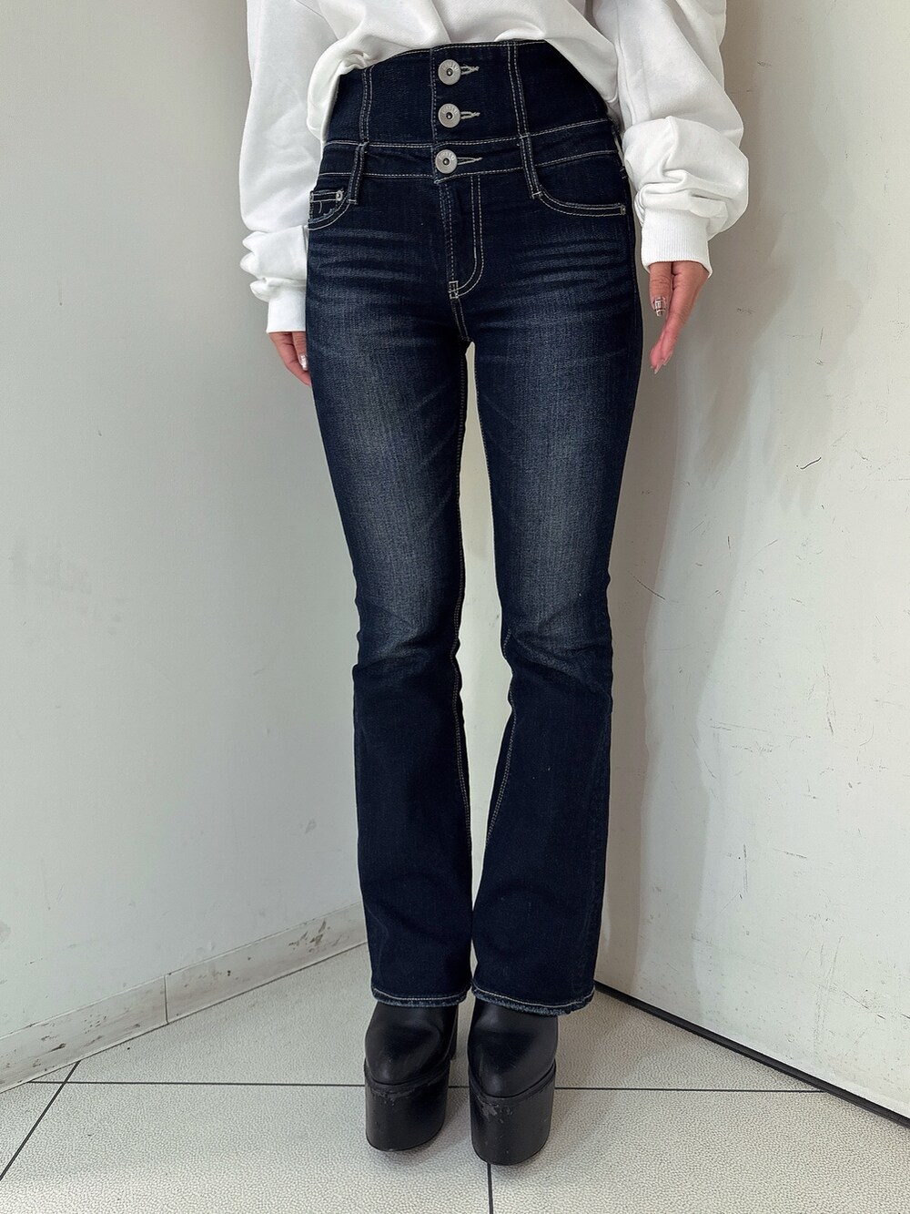 ブルー系のデニムパンツ、ブラック系のブーツ、ブラック系のニット/セーターを着用したレディースの秋コーディネートの8枚目の写真