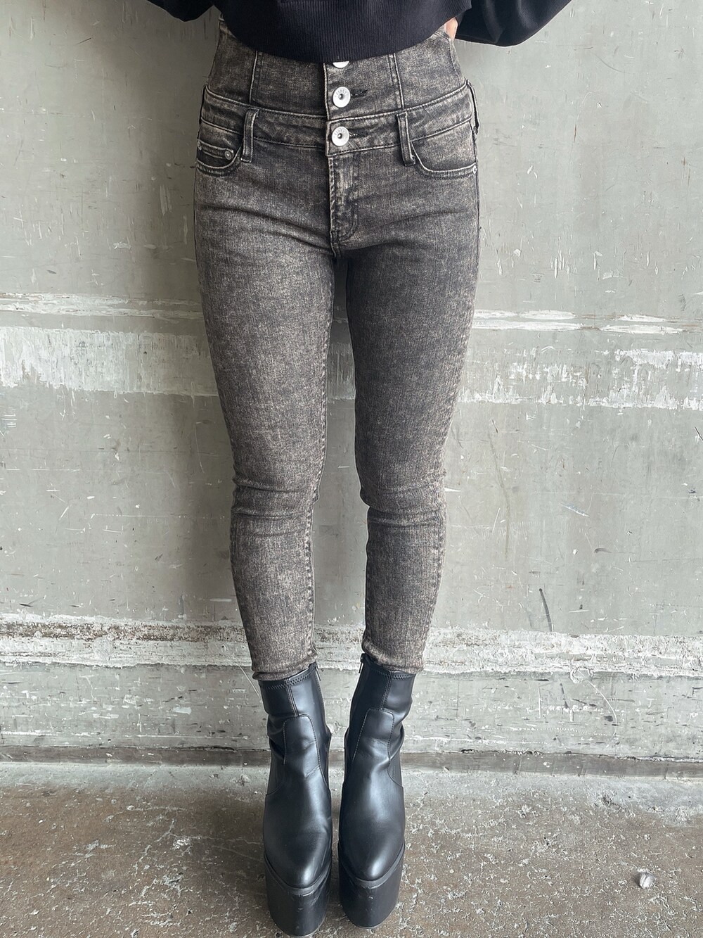 ブラック系のスタジャン、ブラック系のニット/セーター、ブラック系のデニムパンツを着用したレディースの秋コーディネートの10枚目の写真