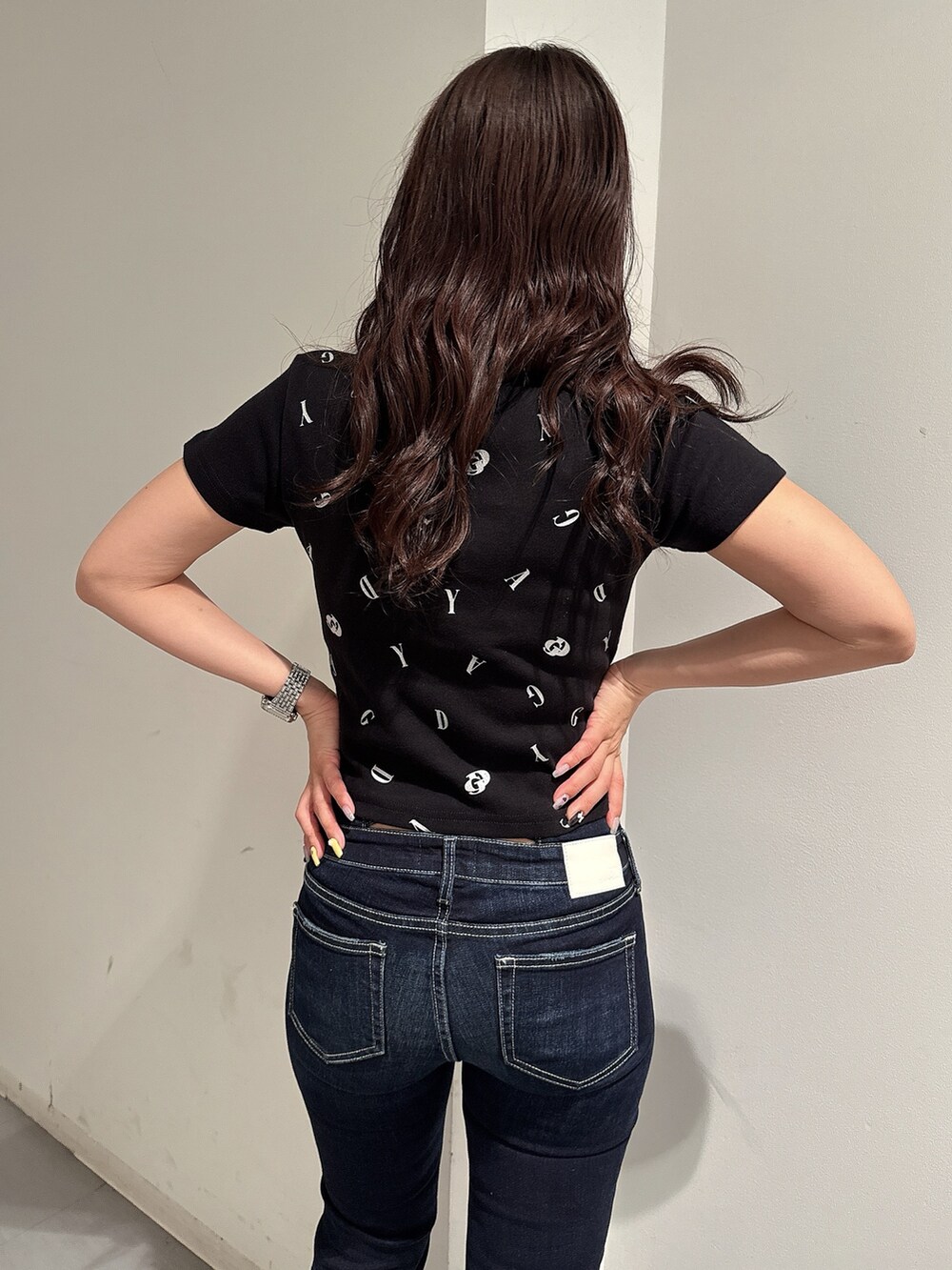 ブラック系のTシャツ/カットソー、ブルー系のデニムパンツ、ブラック系のサンダルを着用したレディースの春コーディネートの6枚目の写真