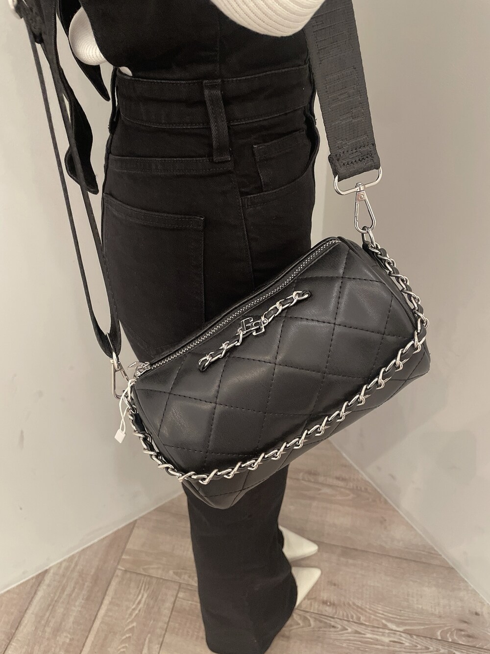 ホワイト系のニット/セーター、ブラック系のサロペット/オーバーオール、ブラック系のハンドバッグを着用したレディースの冬コーディネートの8枚目の写真