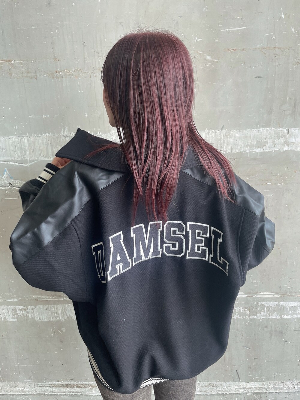 ブラック系のスタジャン、ブラック系のニット/セーター、ブラック系のデニムパンツを着用したレディースの秋コーディネートの6枚目の写真