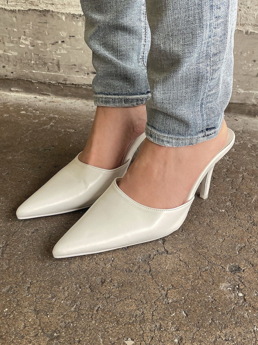 グレー系のニット/セーター、ブルー系のデニムパンツ、ホワイト系のパンプスを着用したレディースの冬コーディネートの10枚目の写真