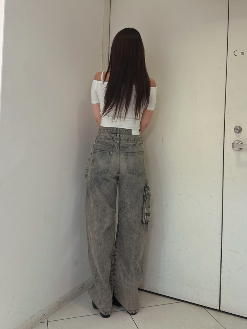 ブラック系のサンダル、ホワイト系のTシャツ/カットソー、ブルー系のデニムパンツを着用したレディースの夏コーディネートの3枚目の写真