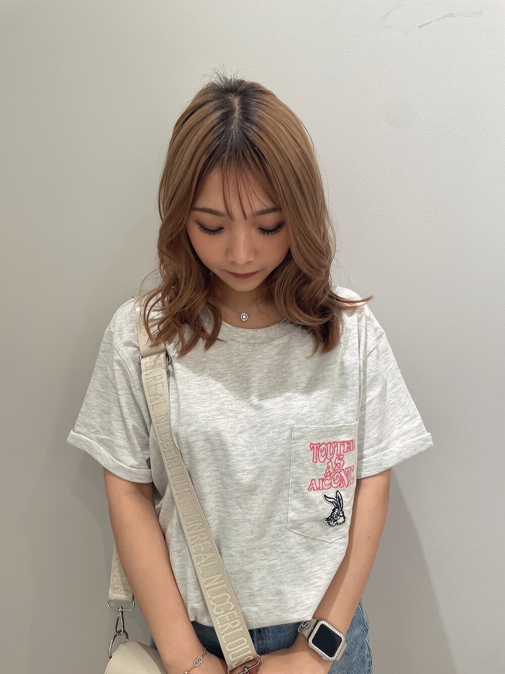 ホワイト系のTシャツ/カットソー、ブルー系のデニムスカート、ホワイト系のサンダルを着用したレディースの春コーディネートの5枚目の写真