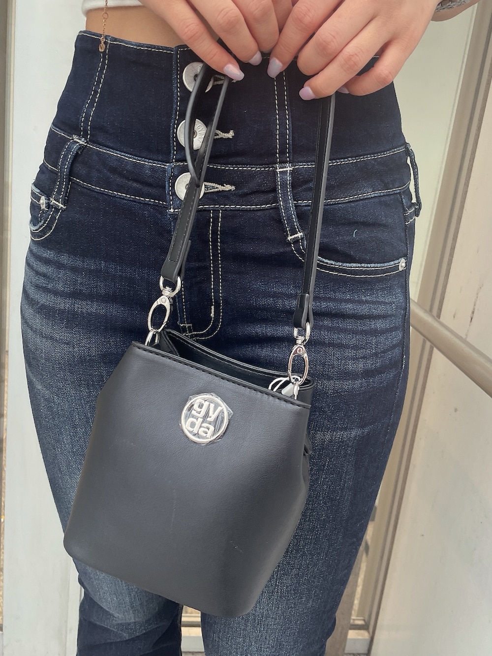 ホワイト系のTシャツ/カットソー、ブルー系のデニムパンツ、ブラック系のショルダーバッグを着用したレディースの夏コーディネートの8枚目の写真