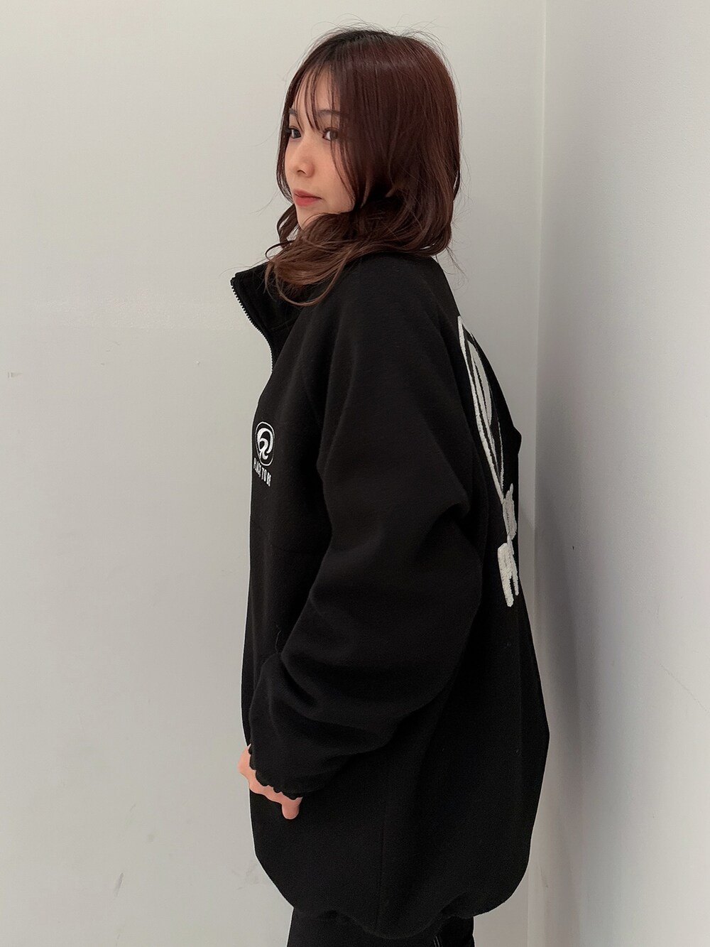 ブラック系のブルゾン、ブラック系のデニムパンツ、ブラック系のブーツを着用したレディースの冬コーディネートの5枚目の写真