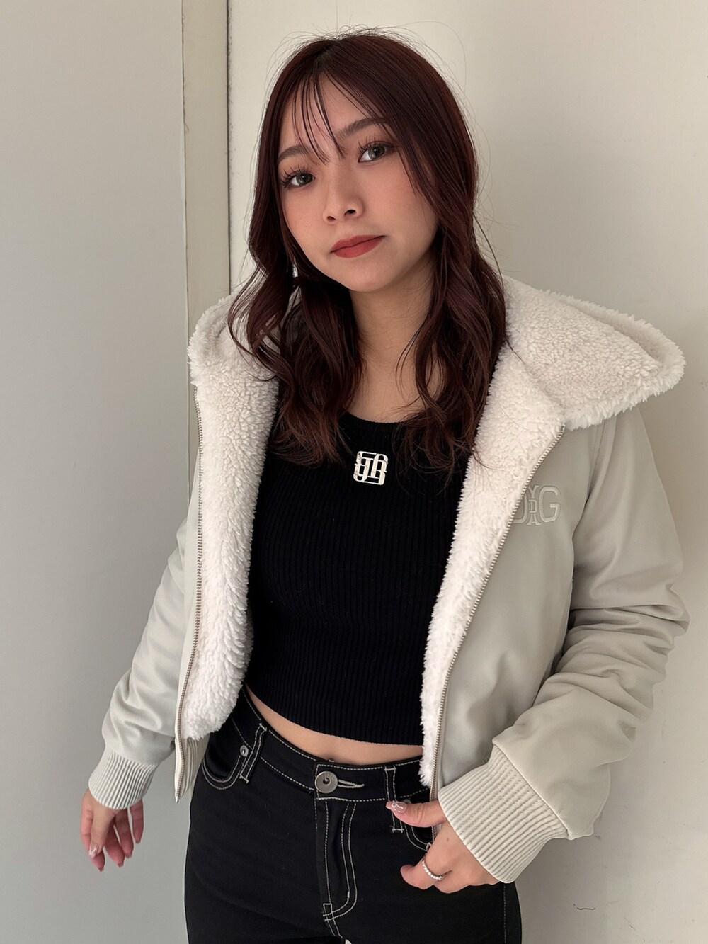 ブラック系のデニムパンツ、ブラック系のブーツ、ホワイト系のその他アウターを着用したレディースの冬コーディネートの4枚目の写真