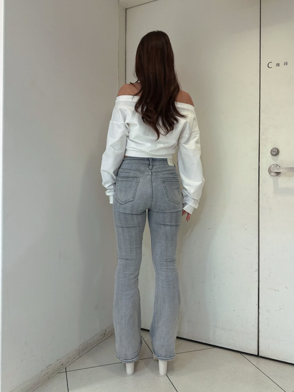 ブルー系のデニムパンツ、ホワイト系のスウェット、ホワイト系のブーツを着用したレディースの夏コーディネートの3枚目の写真