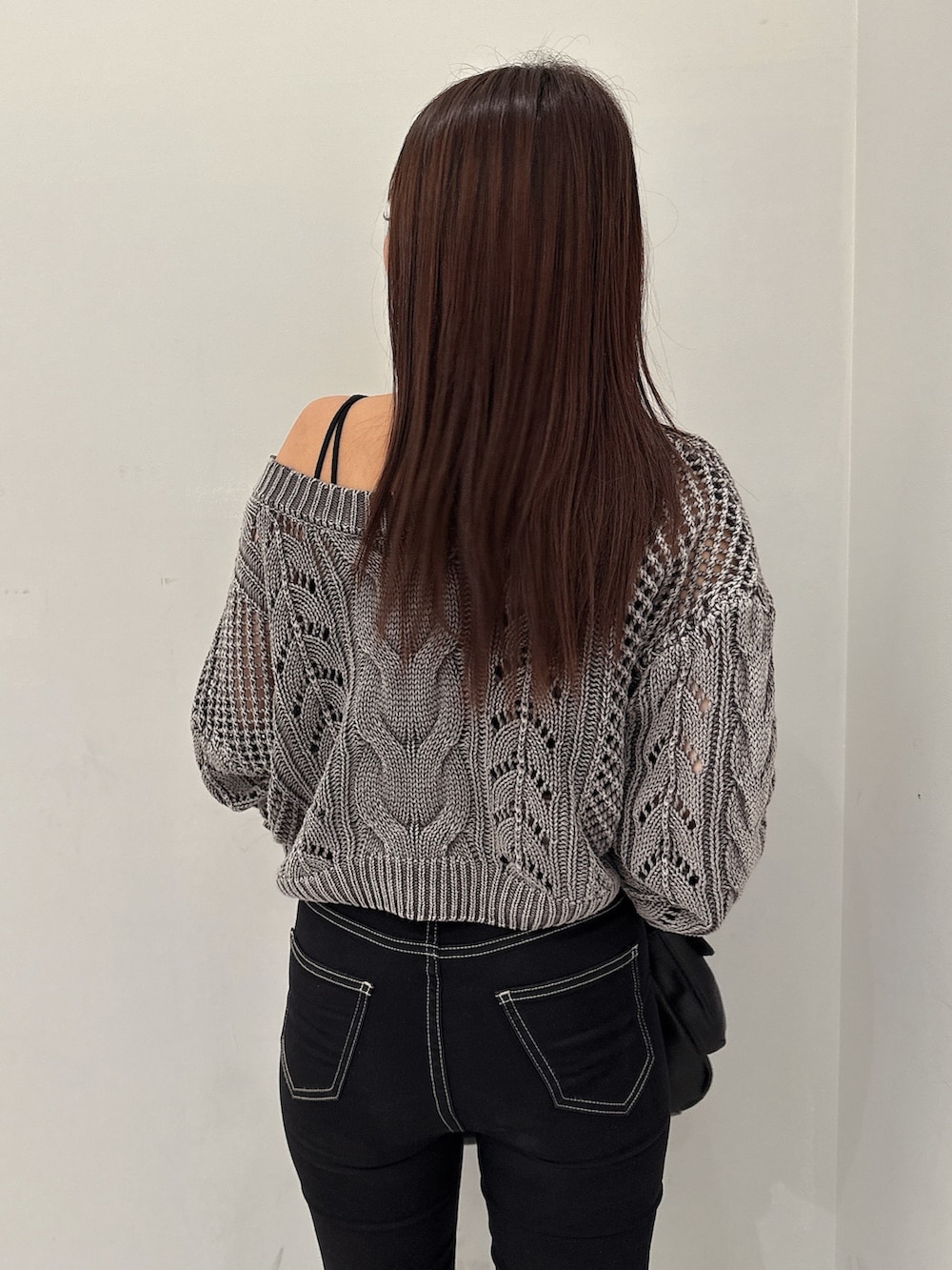 ブラック系のデニムパンツ、ブラック系のブーツ、グレー系のカーディガン/ボレロを着用したレディースの夏コーディネートの6枚目の写真