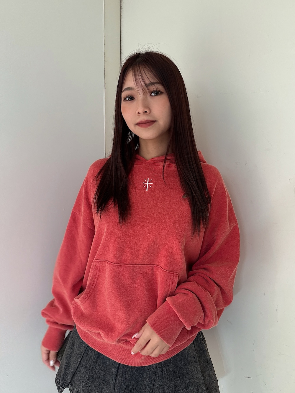 レッド系のパーカー、その他のデニムスカート、ブラック系のブーツを着用したレディースの秋コーディネートの4枚目の写真