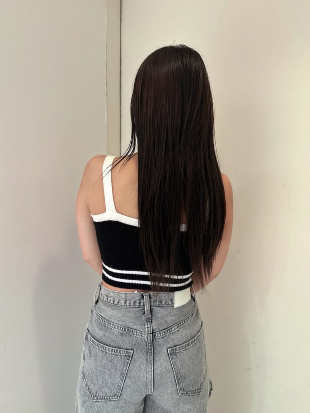 ブラック系のサンダル、ブルー系のデニムパンツ、ブラック系のキャミソールを着用したレディースの春コーディネートの6枚目の写真