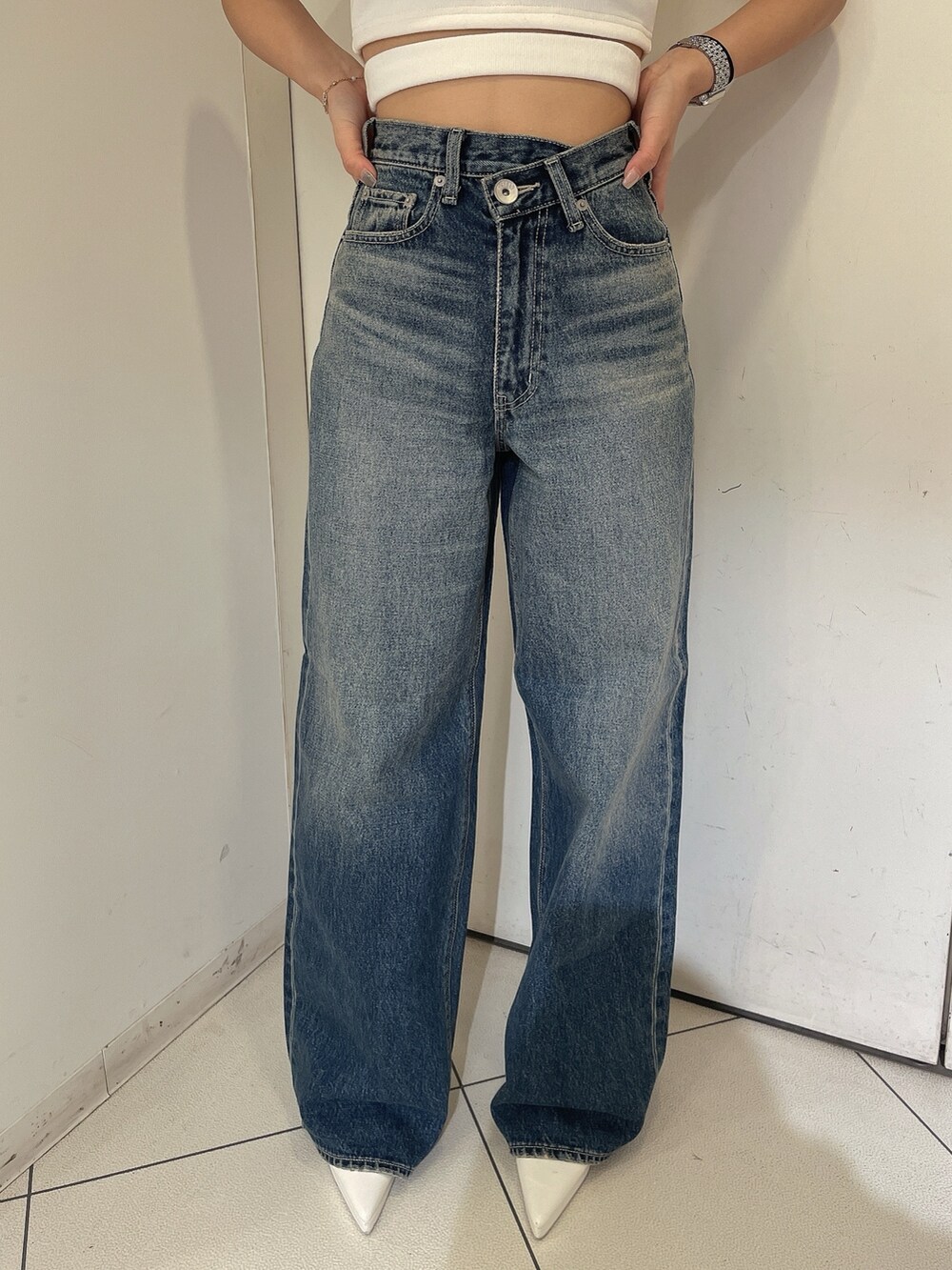 ブルー系のデニムパンツ、ブラック系のライダースジャケット、ホワイト系のタンクトップを着用したレディースの冬コーディネートの6枚目の写真