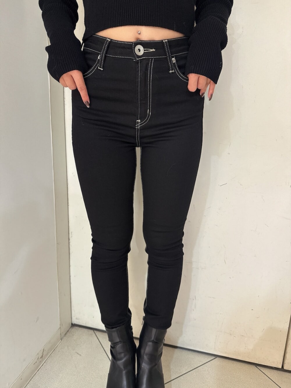 ブラック系のデニムパンツ、ブラック系のニット/セーター、ベージュ系のスタジャンを着用したレディースの秋コーディネートの10枚目の写真