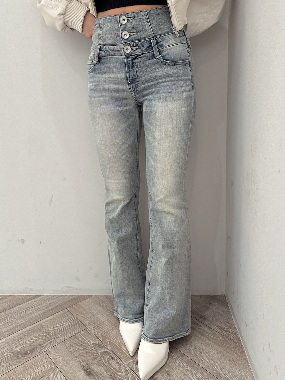 ホワイト系のブルゾン、ブラック系のニット/セーター、ブルー系のデニムパンツを着用したレディースの冬コーディネートの7枚目の写真