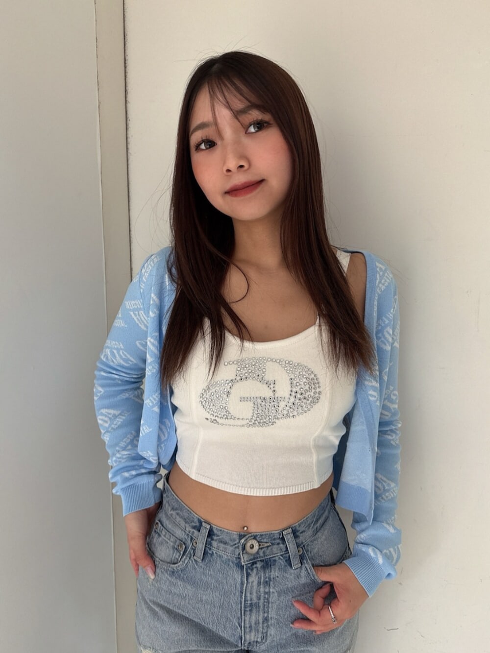 ブラック系のサンダル、ブルー系のデニムパンツ、ホワイト系のキャミソールを着用したレディースの夏コーディネートの4枚目の写真