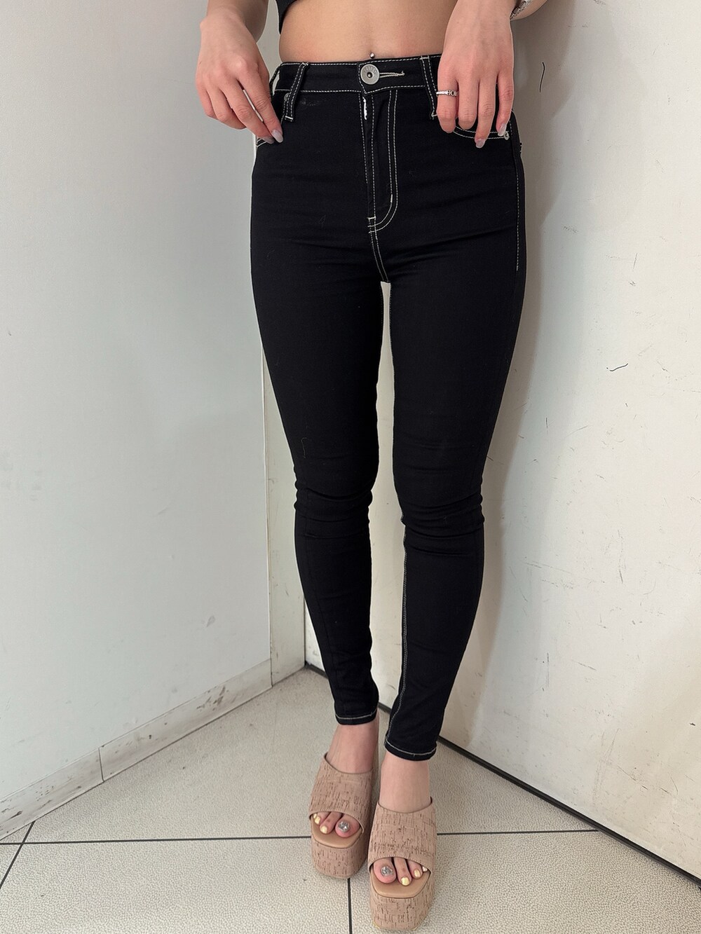 ブラック系のニット/セーター、ブラック系のデニムパンツ、ホワイト系のシャツ/ブラウスを着用したレディースの春コーディネートの8枚目の写真