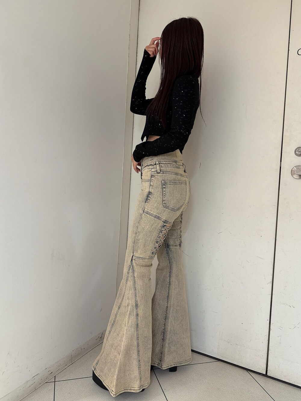 ブラック系のTシャツ/カットソー、ブルー系のデニムパンツ、ブラック系のブーツを着用したレディースの秋コーディネートの2枚目の写真