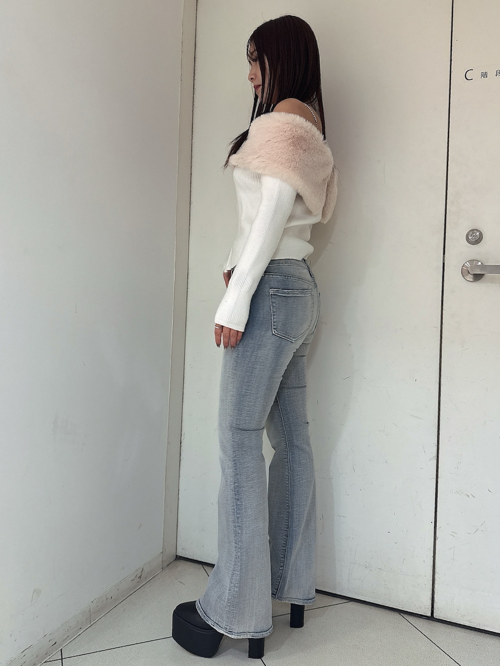 ホワイト系のニット/セーター、ブルー系のデニムパンツ、ブラック系のブーツを着用したレディースの秋コーディネートの2枚目の写真