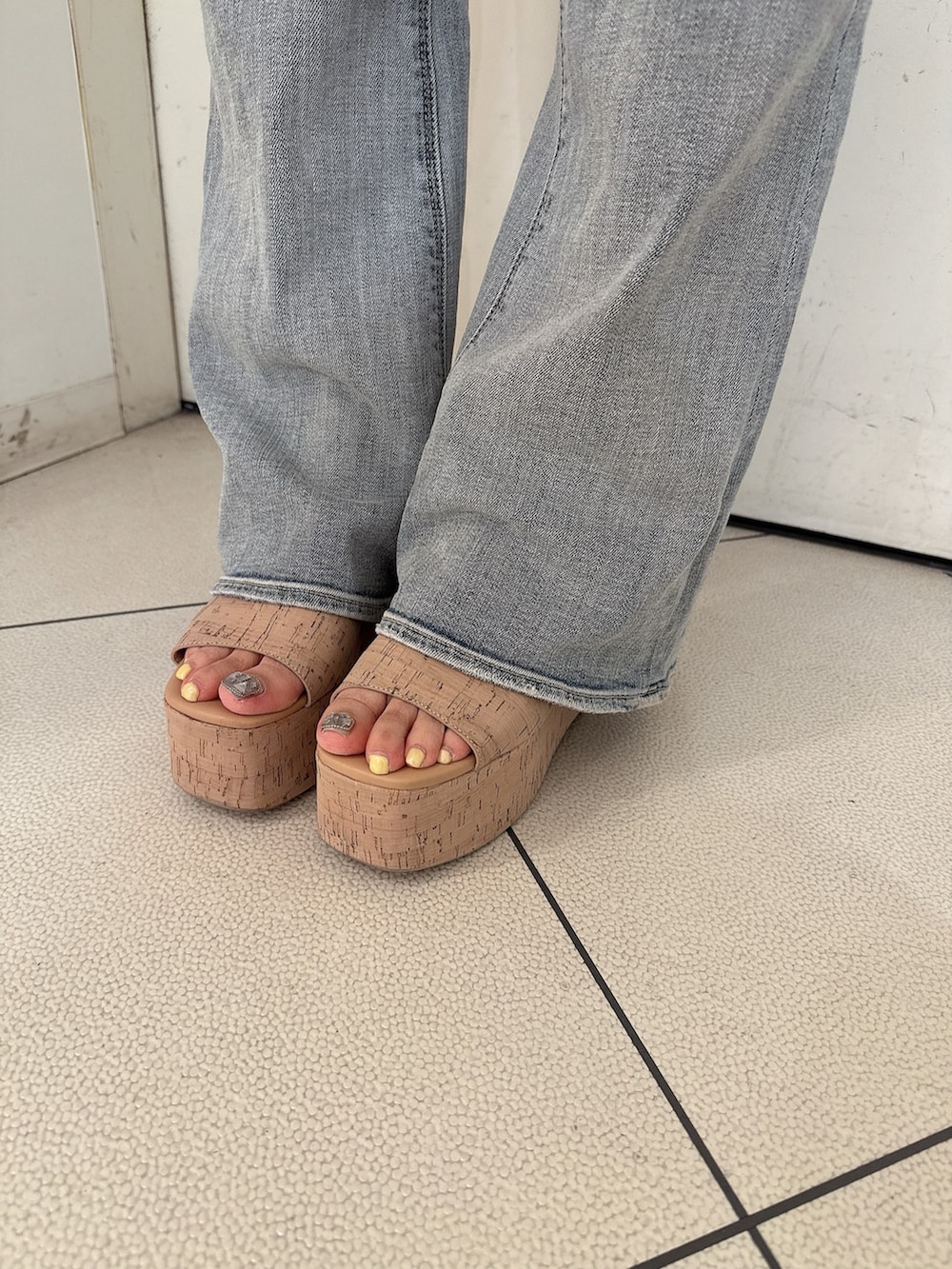 ブルー系のデニムパンツ、ブラック系のニット/セーター、ホワイト系のサンダルを着用したレディースの春コーディネートの9枚目の写真