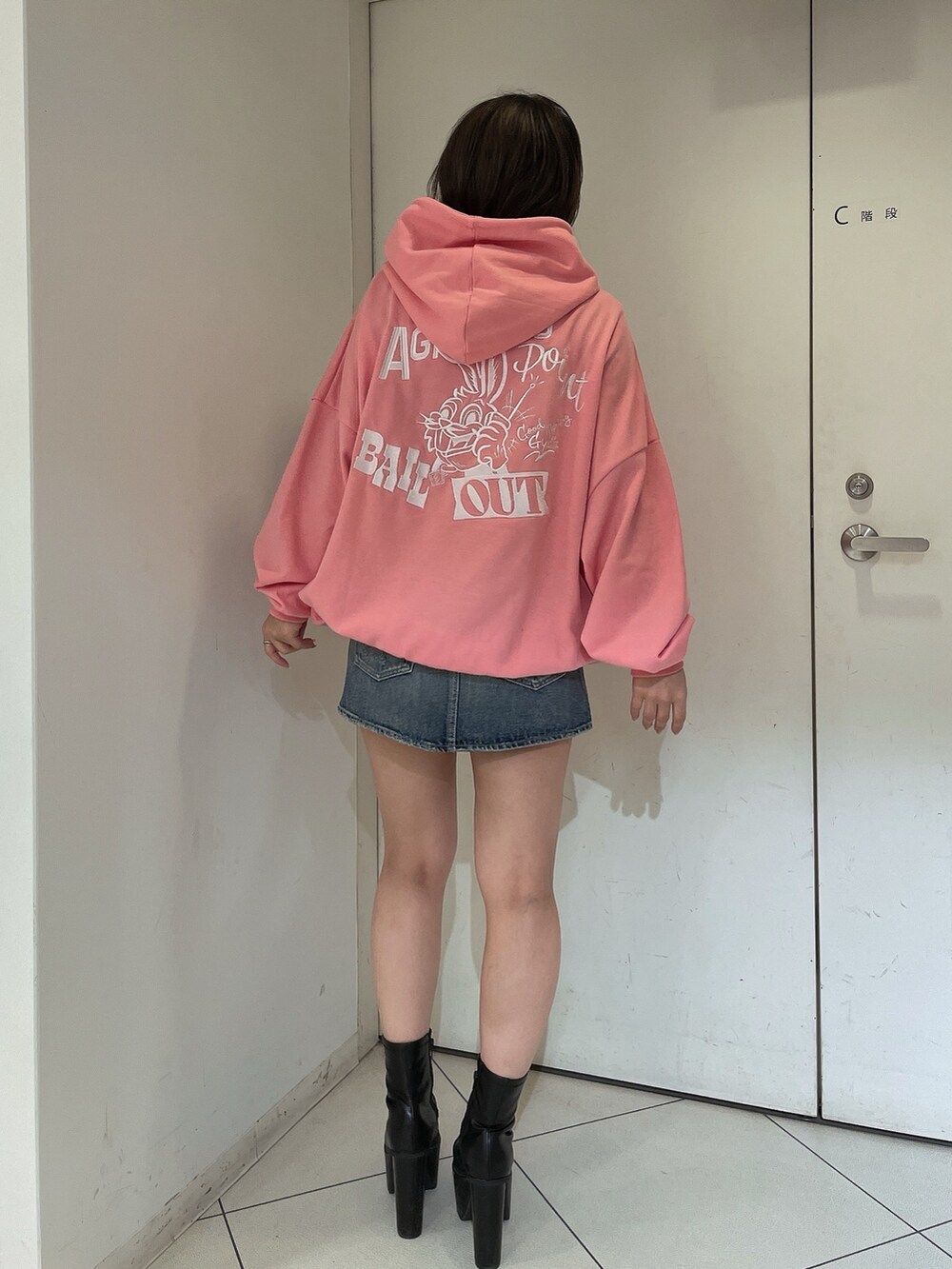 ピンク系のパーカー、ブルー系のデニムスカートを着用したレディースの冬コーディネートの2枚目の写真