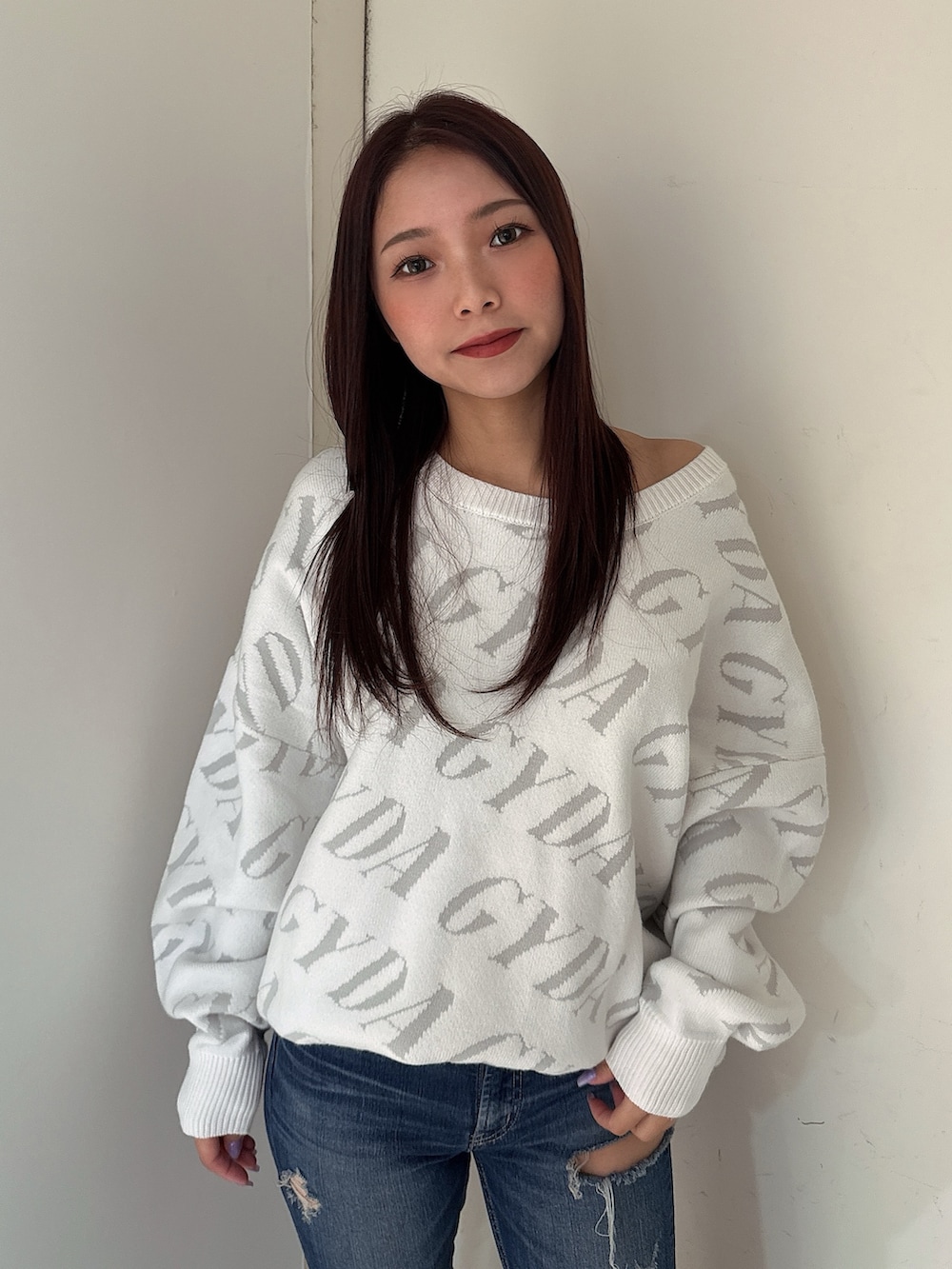 ホワイト系のニット/セーター、ブルー系のデニムパンツ、ブラック系のブーツを着用したレディースの秋コーディネートの4枚目の写真