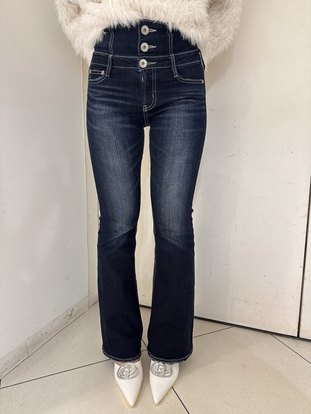 ホワイト系のニット/セーター、ブルー系のデニムパンツ、ホワイト系のパンプスを着用したレディースの秋コーディネートの8枚目の写真