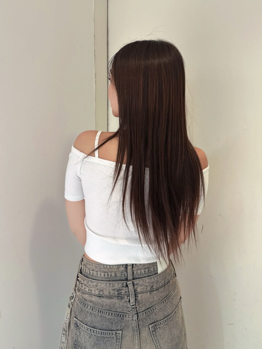 ブラック系のサンダル、ホワイト系のTシャツ/カットソー、ブルー系のデニムパンツを着用したレディースの夏コーディネートの6枚目の写真