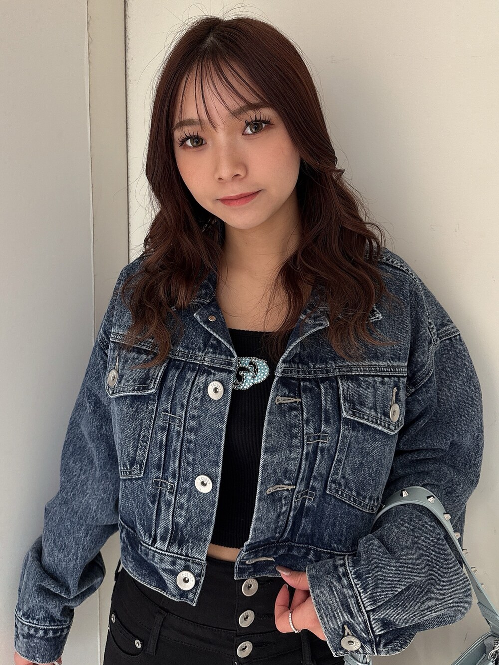 ブラック系のTシャツ/カットソー、ブルー系のデニムジャケット、ブラック系のデニムパンツを着用したレディースの春コーディネートの4枚目の写真