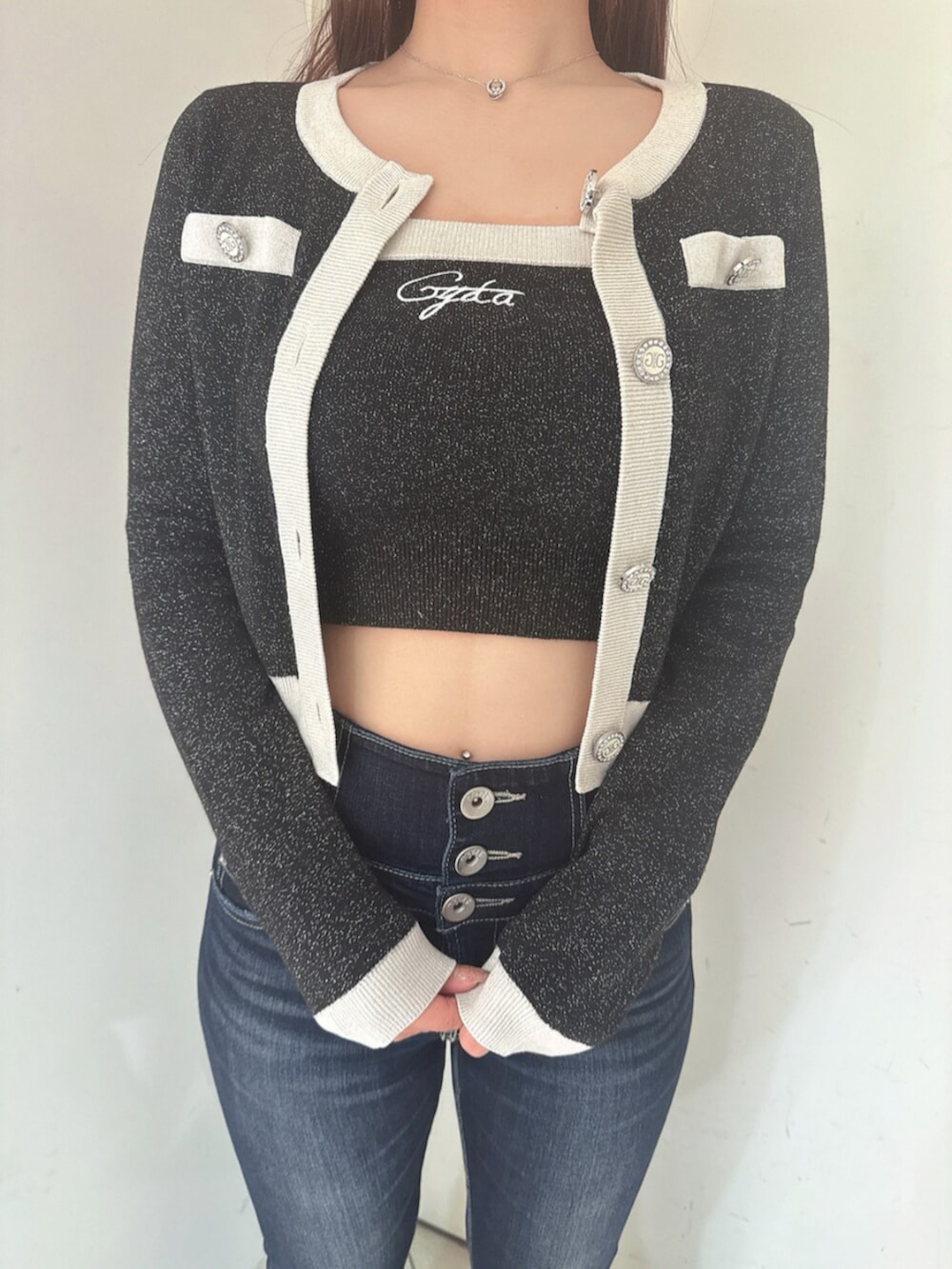 ブルー系のデニムパンツ、ブラック系のサンダル、ブラック系のニット/セーターを着用したレディースの春コーディネートの7枚目の写真