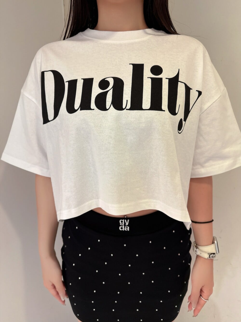 ブラック系のスカート、ホワイト系のTシャツ/カットソー、ブラック系のサンダルを着用したレディースの夏コーディネートの7枚目の写真