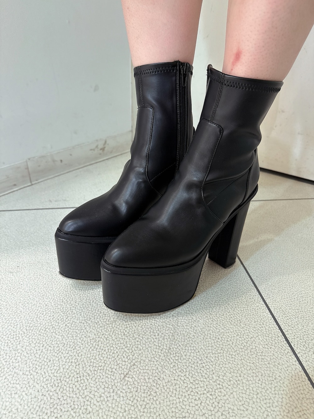 グレー系のデニムパンツ、ブラック系のブーツ、グレー系のニット/セーターを着用したレディースの冬コーディネートの8枚目の写真