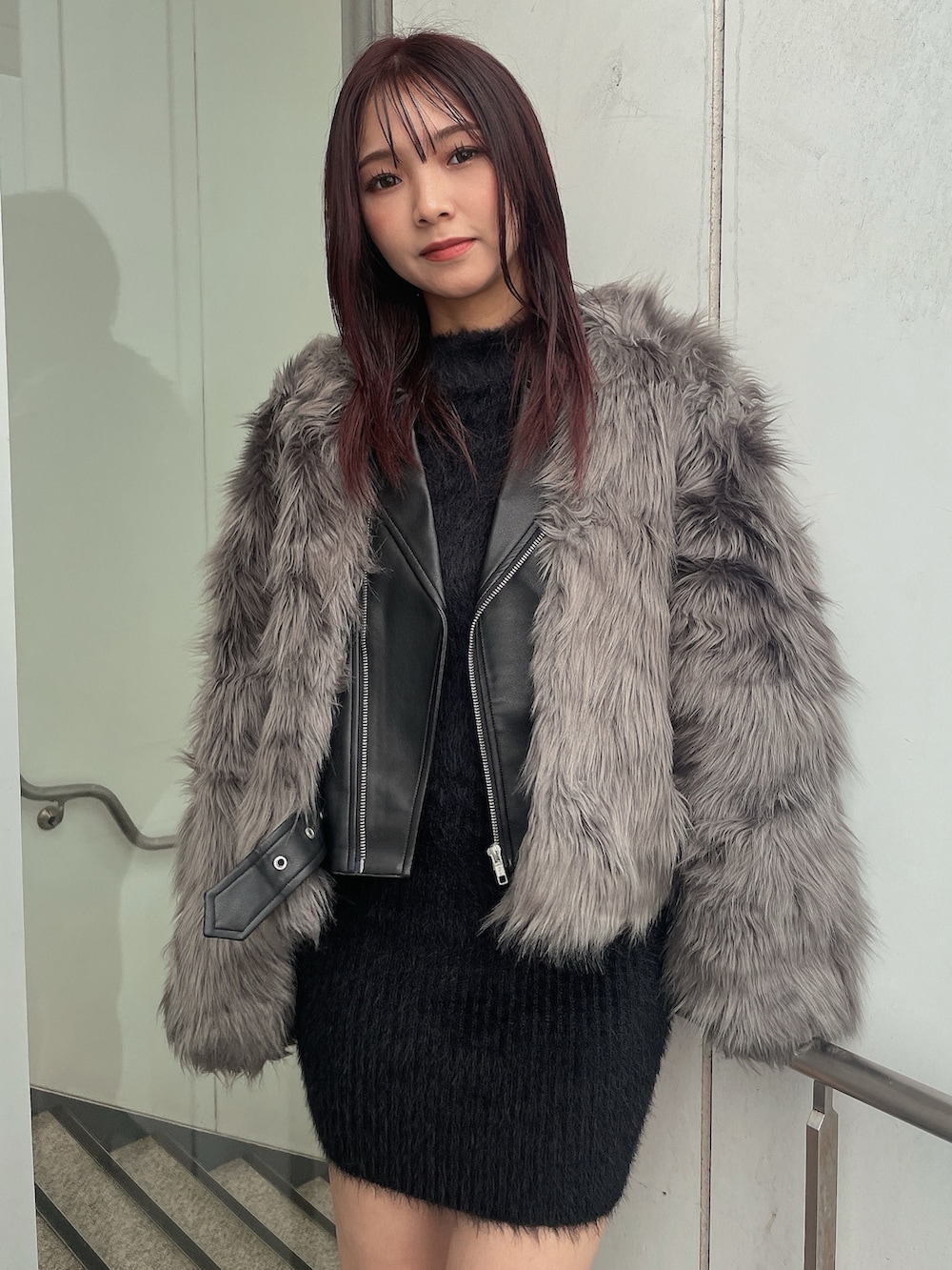 ブラック系のブーツ、ブラック系のワンピース、グレー系のライダースジャケットを着用したレディースの秋コーディネートの3枚目の写真