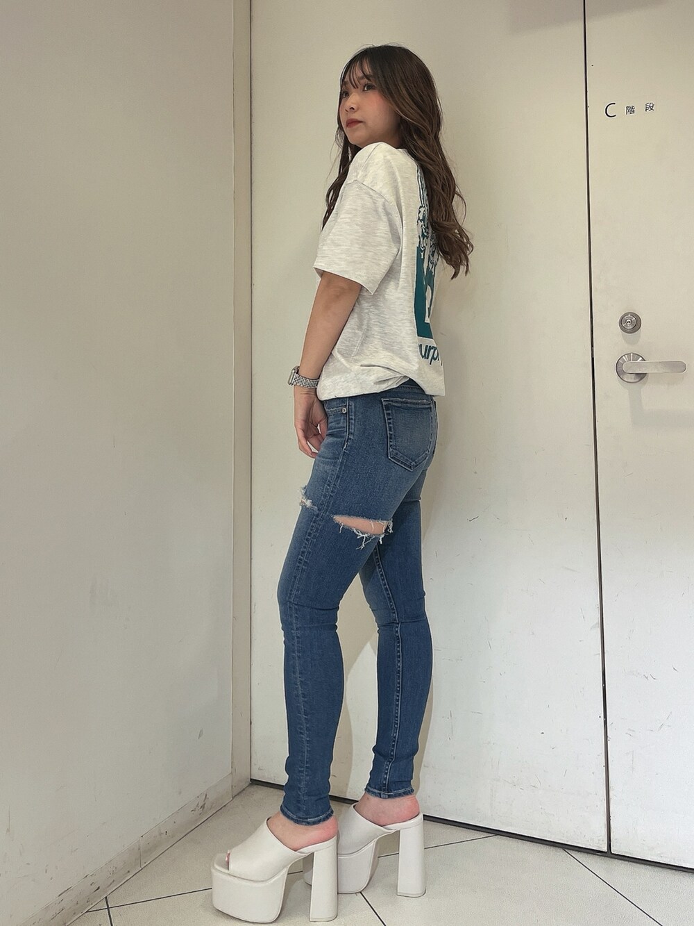 グレー系のTシャツ/カットソー、ブルー系のデニムパンツ、ホワイト系のサンダルを着用したレディースの夏コーディネートの2枚目の写真