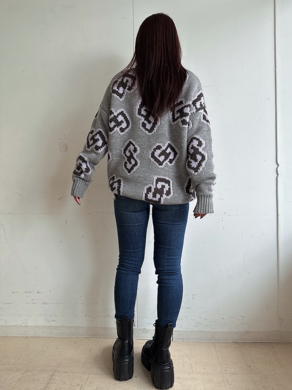 グレー系のニット/セーター、ブルー系のデニムパンツ、ブラック系のブーツを着用したレディースの秋コーディネートの3枚目の写真