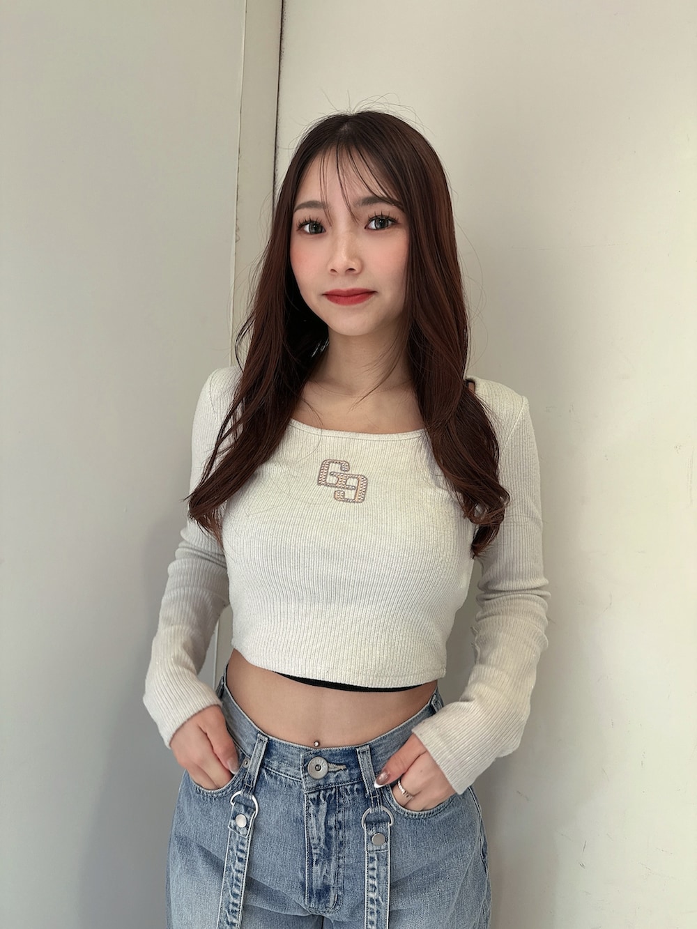 ブルー系のデニムパンツ、ブラック系のサンダル、ホワイト系のTシャツ/カットソーを着用したレディースの春コーディネートの4枚目の写真