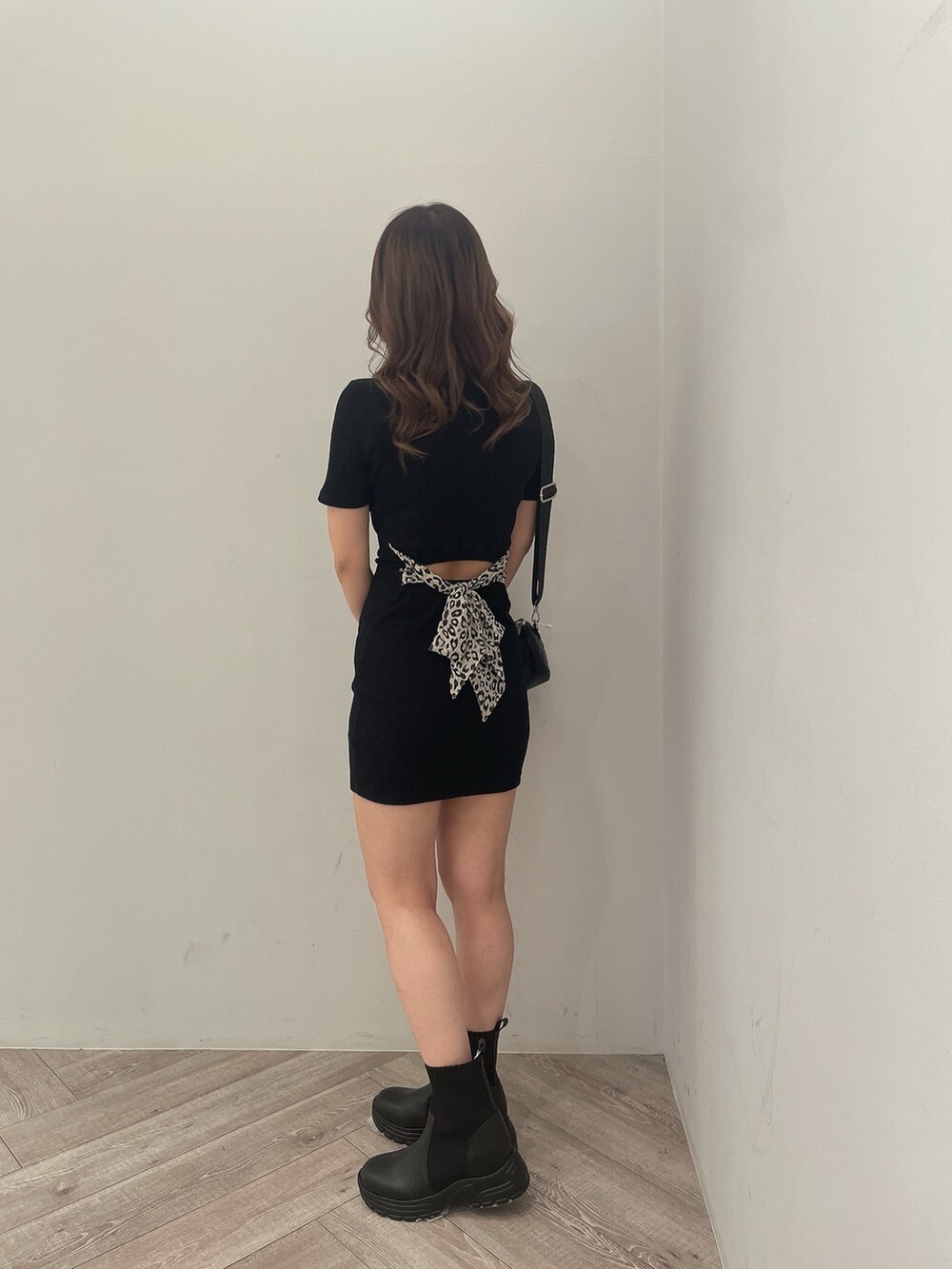 ブラック系のハンドバッグ、ブラック系のブーツ、ブラック系のワンピースを着用したレディースの冬コーディネートの2枚目の写真