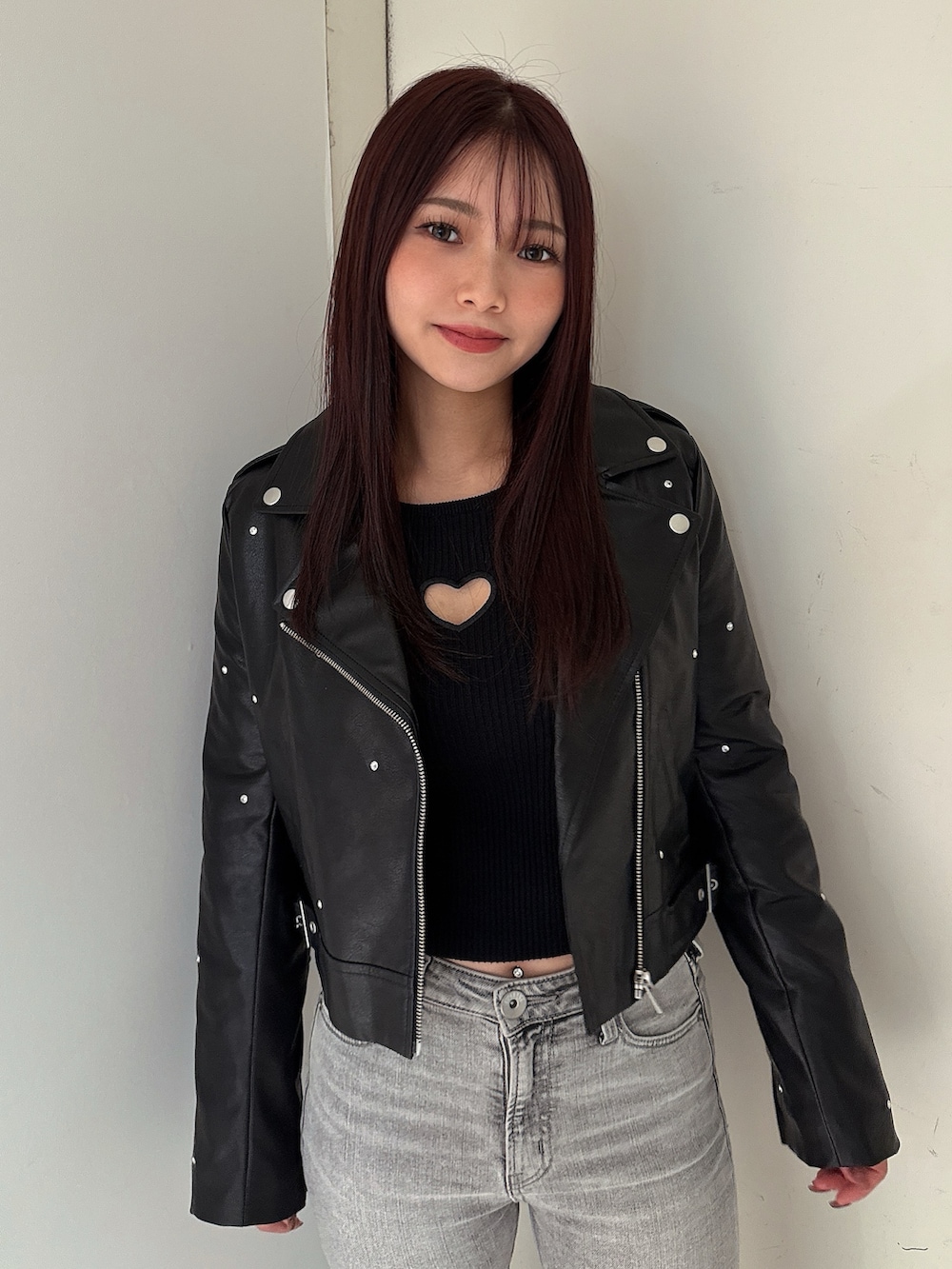 グレー系のデニムパンツ、ブラック系のブーツ、ブラック系のライダースジャケットを着用したレディースの夏コーディネートの4枚目の写真