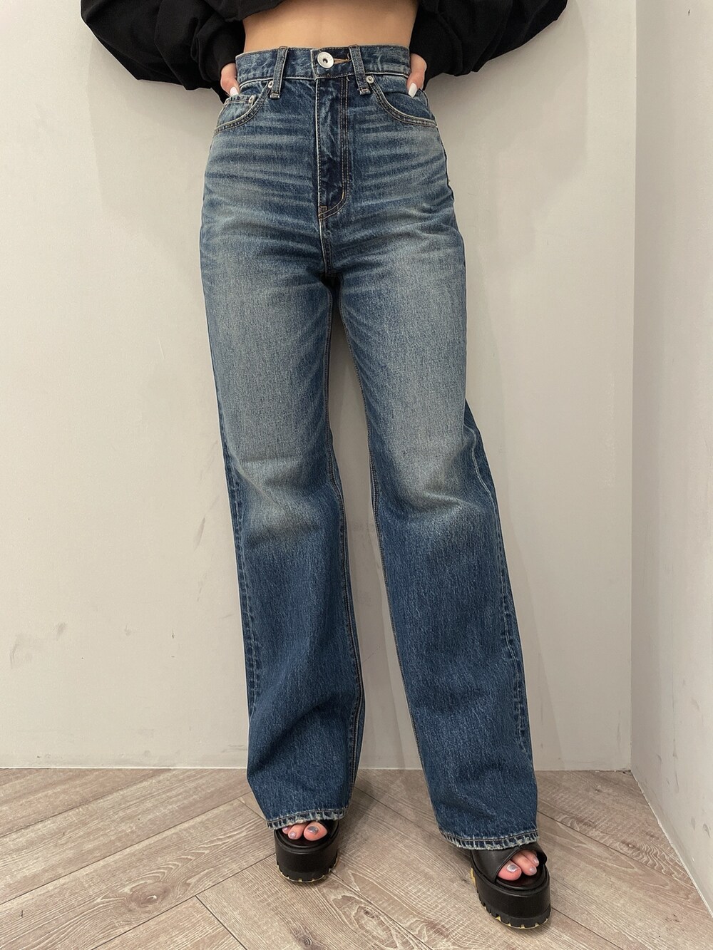 ブラック系のTシャツ/カットソー、ブルー系のデニムパンツ、ブラック系のブーツを着用したレディースの春コーディネートの8枚目の写真