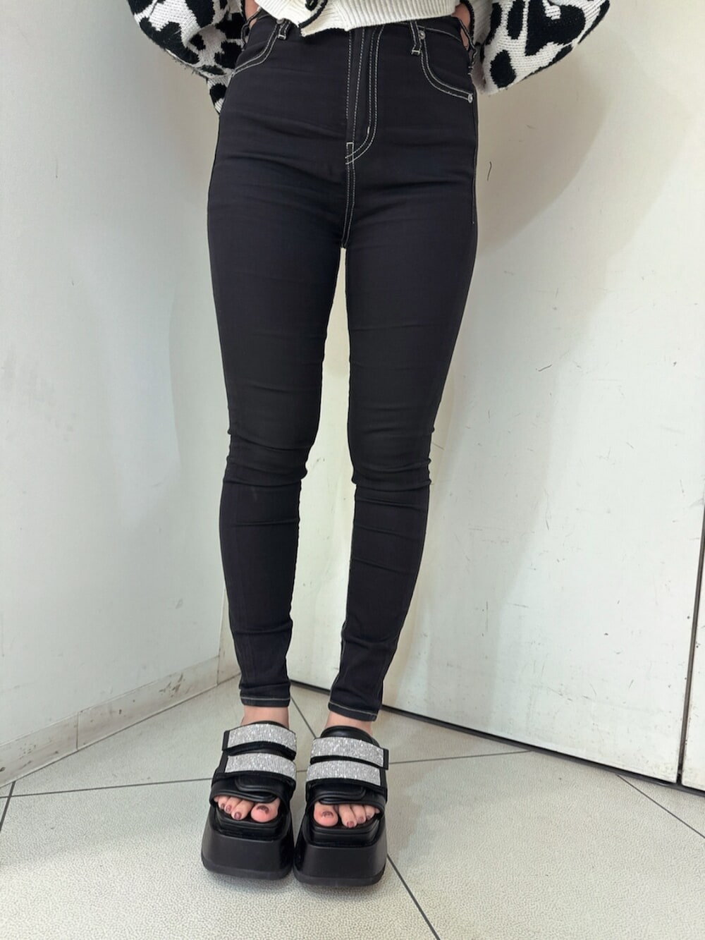 ブラック系のデニムパンツ、ブラック系のサンダル、ホワイト系のカーディガン/ボレロを着用したレディースの春コーディネートの8枚目の写真