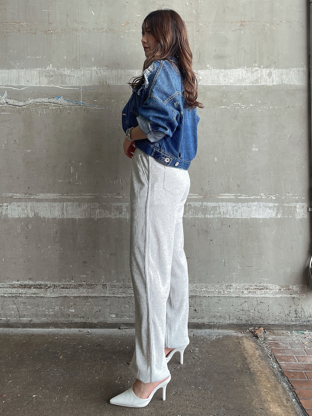 ブルー系のデニムジャケット、グレー系のキャミソール、グレー系のスウェットパンツを着用したレディースの夏コーディネートの2枚目の写真