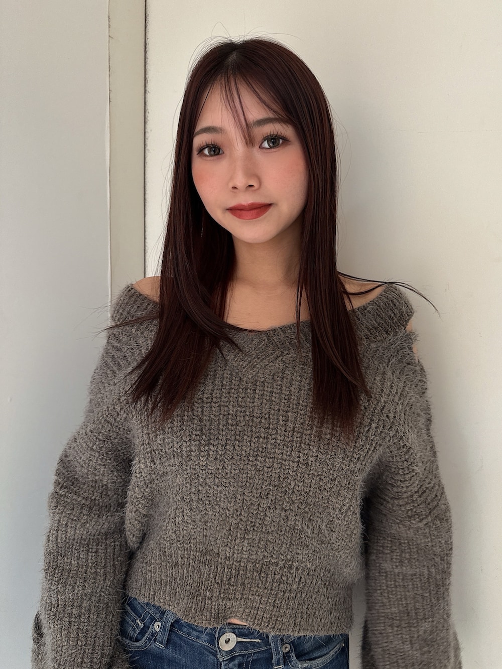 ブルー系のデニムパンツ、ブラック系のブーツ、グレー系のニット/セーターを着用したレディースの秋コーディネートの4枚目の写真