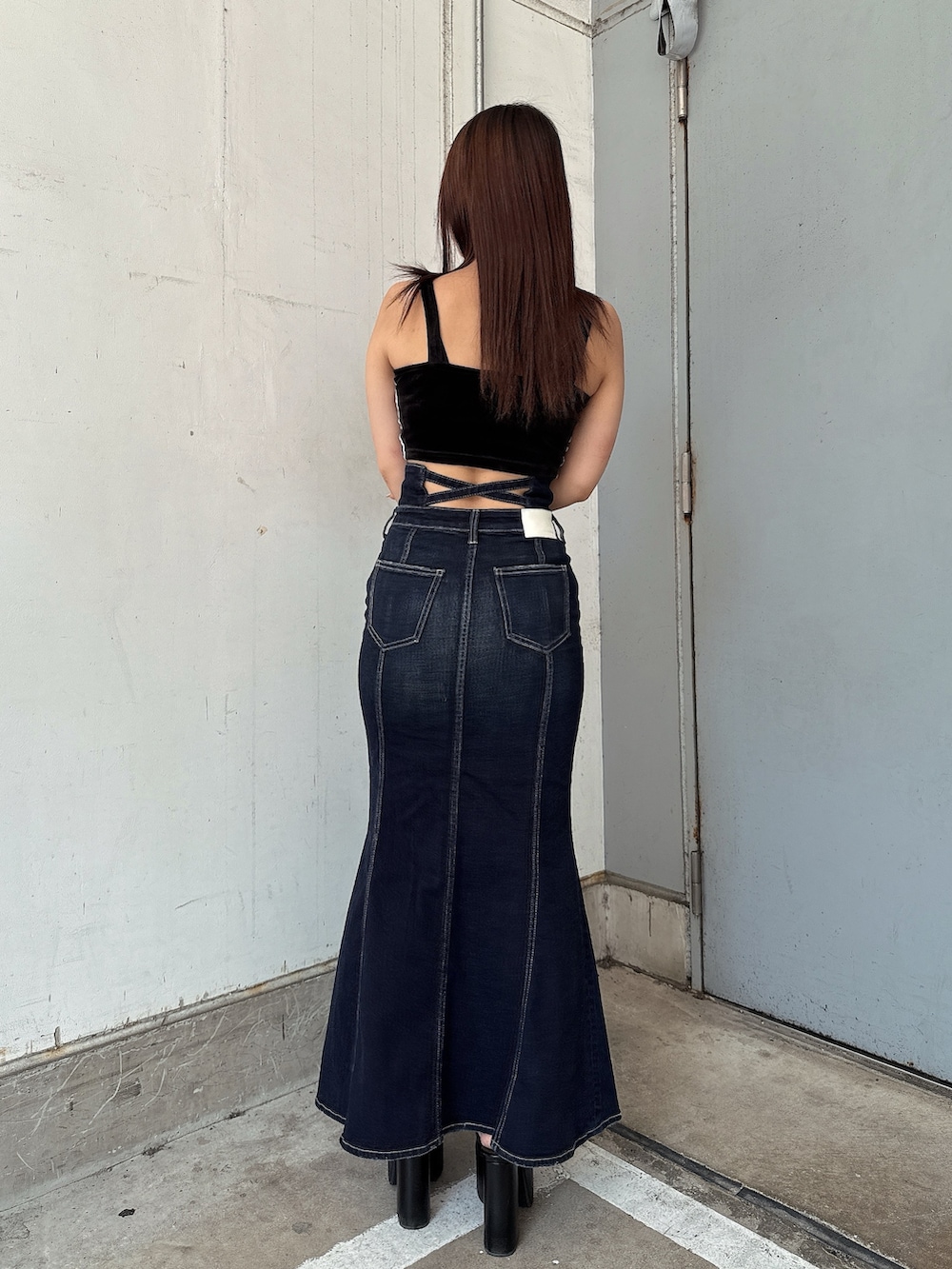 ブラック系のキャミソール、ブルー系のデニムスカート、ブラック系のサンダルを着用したレディースの夏コーディネートの3枚目の写真