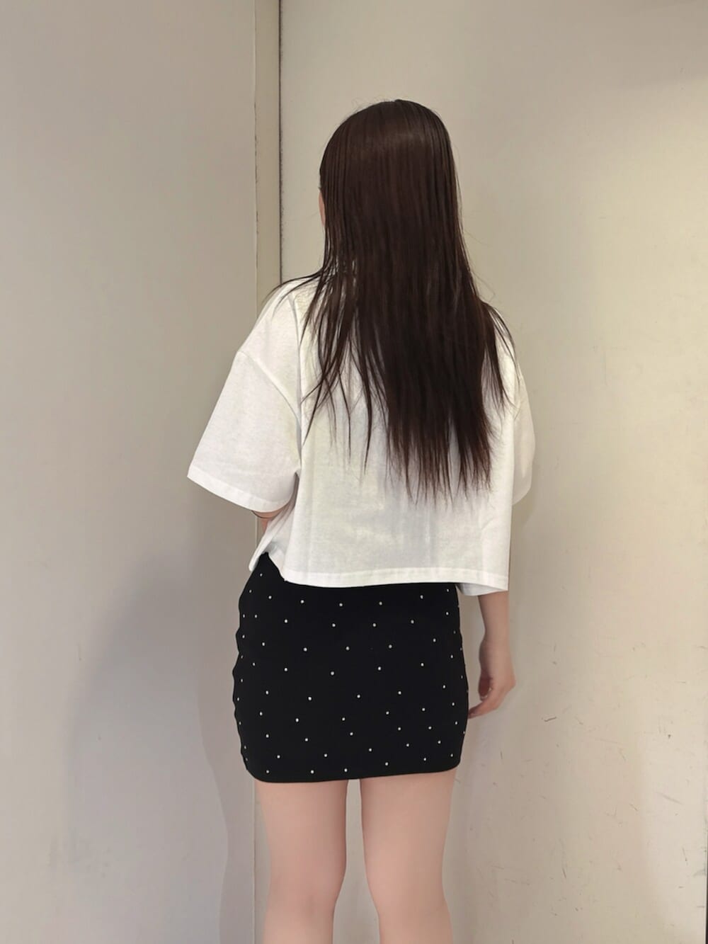 ブラック系のスカート、ホワイト系のTシャツ/カットソー、ブラック系のサンダルを着用したレディースの夏コーディネートの6枚目の写真