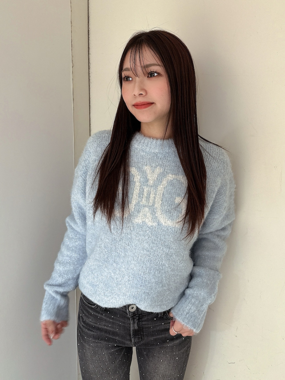 ブラック系のブーツ、ブルー系のニット/セーター、ブラック系のデニムパンツを着用したレディースの冬コーディネートの4枚目の写真