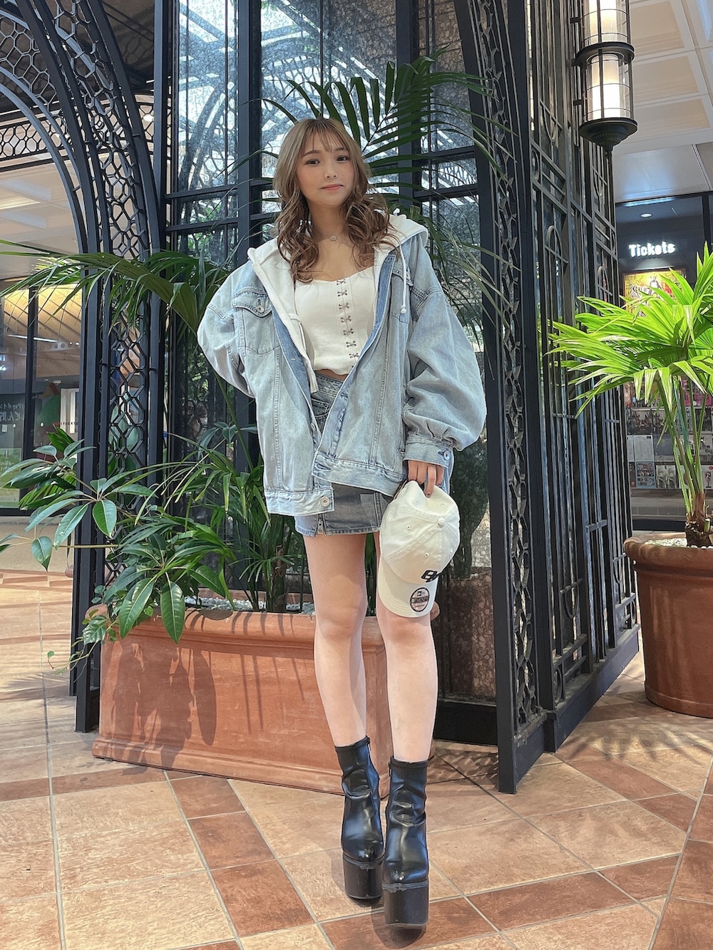 ホワイト系のキャミソール、ホワイト系のパーカー、ブルー系のデニムジャケットを着用したレディースの春コーディネートの2枚目の写真